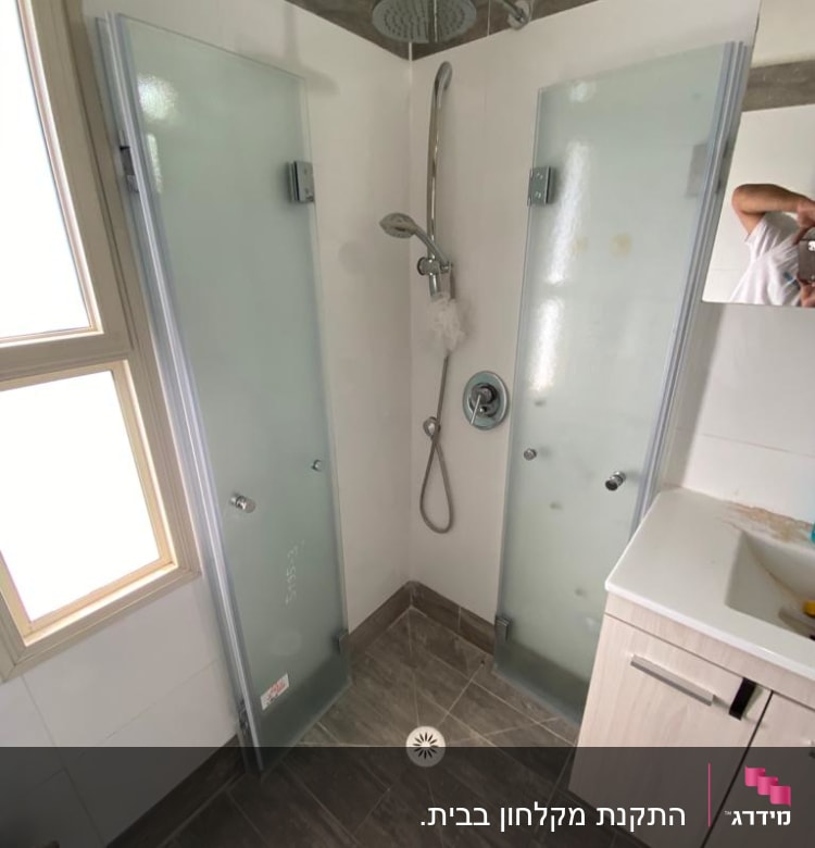 מקלחת עם דלתות זכוכית וברז גשם